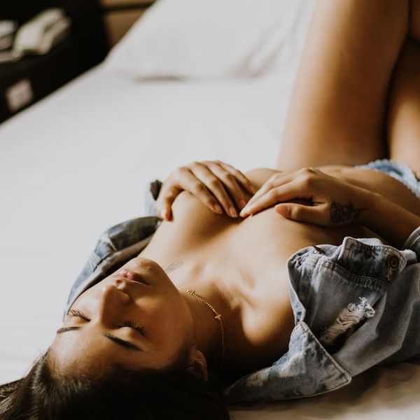 Woman in a calm, focused pose in a minimalist setting.